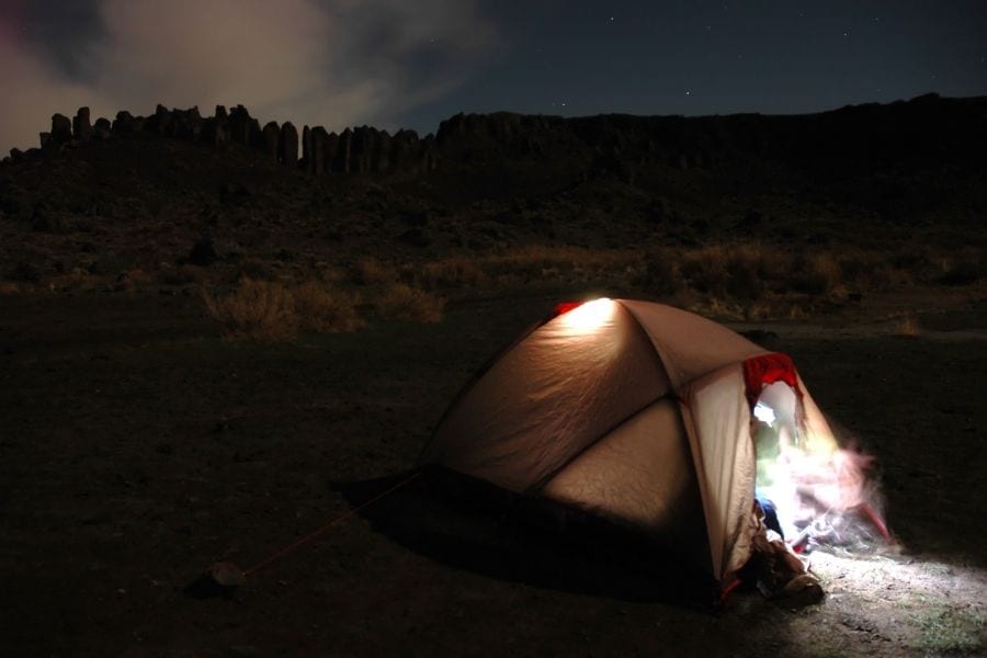 Lanterns light up a tent in the middle of the desert