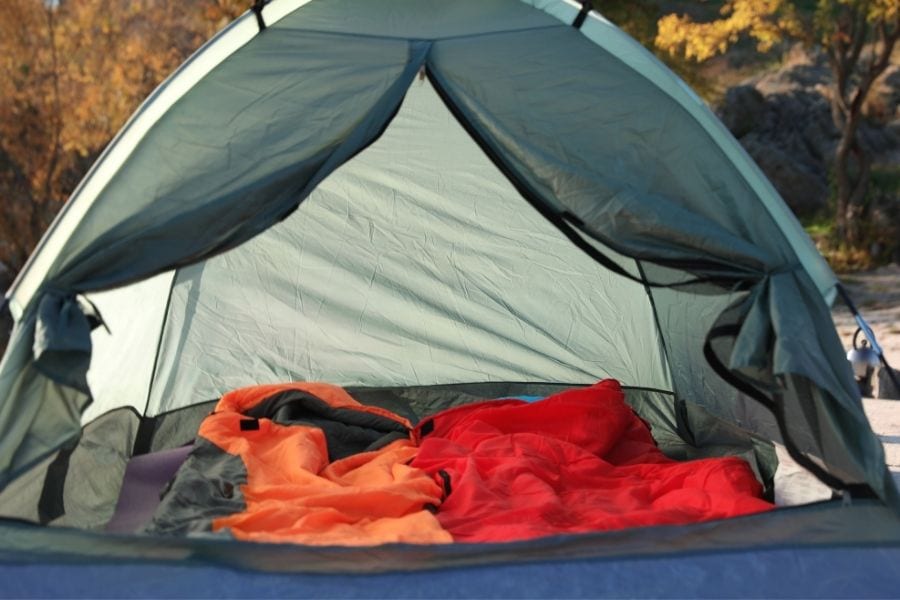 Two sleeping bags are set up in a 3-person tent great for beginner campers